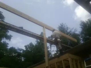 Carpenter setting a ridge beam over a new addition frame — Ice Dam Removal by Roofing Brothers in West Glacier