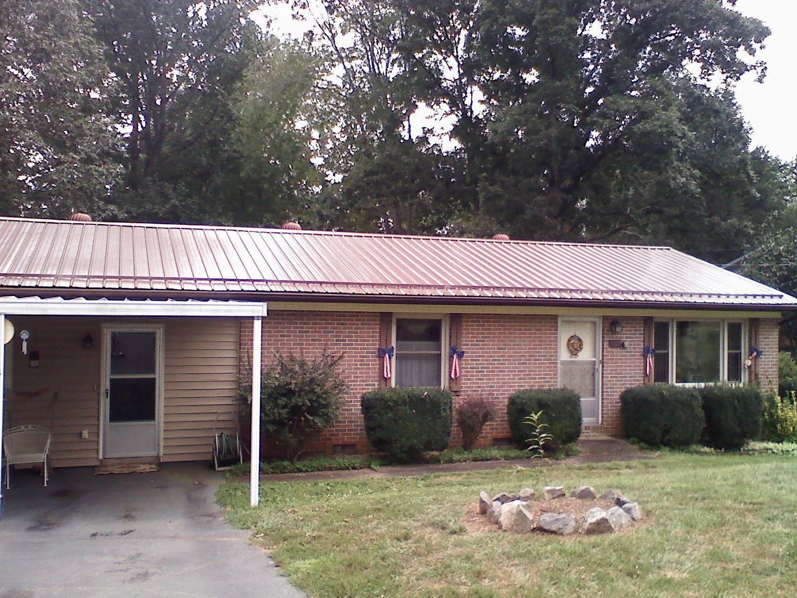 Bronze metal roof and carport on a brick ranch home — Roof Repair work by our crew in West Glacier